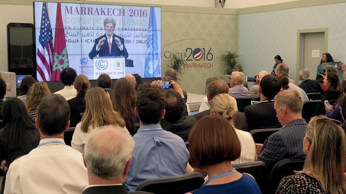 Varias personas siguen a través de una pantalla la conferencia ofrecida por el secretario de Estado de EEUU, John Kerry, en la COP22