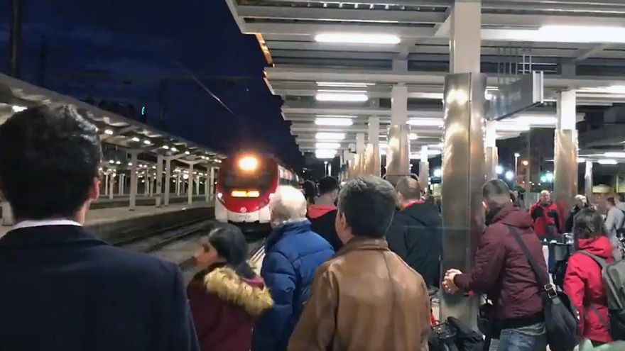 Usuarios esperan un tren de Cercanía de la línea C-2 en la estación del Norte de Valencia que ha llegaba con 20 minutos de retraso.