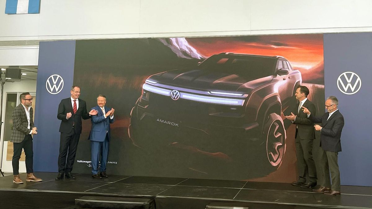 EL CEO de VW Argentina, Marcellus Puig (der.) junto a varios altos funcionarios del Grupo celebrando el anuncio de inversión. Detrás, una imagen de la futura pickup.