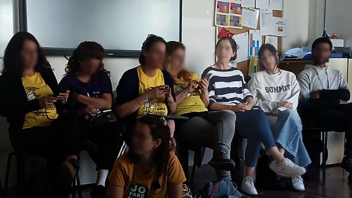 Imagen de la asamblea de docentes de Barcelona. Con camiseta de rayas blancas y azules, y con jersey gris, las dos supuestas agentes de los Mossos