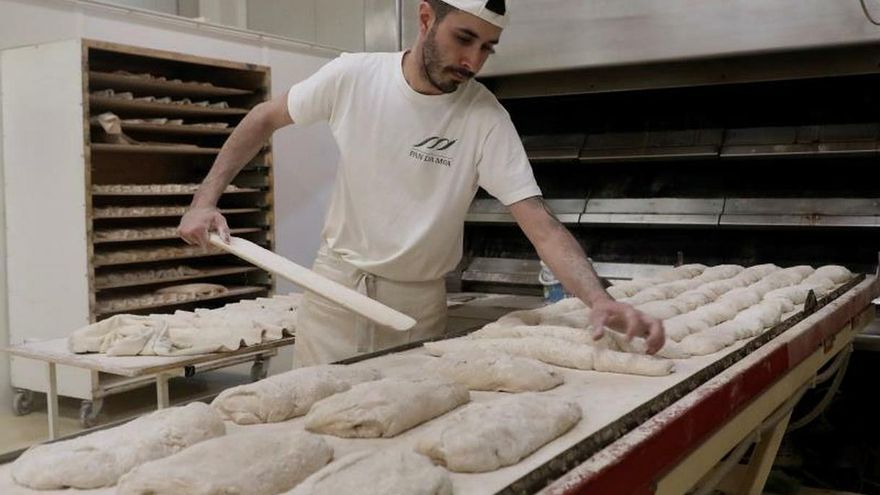 Un panadero trabaja en un horno de pan de Santiago de Compostela. No solamente de pan vive el hombre, pero en momentos como el actual los puestos que despachan este alimento como en Santiago de Compostela con "Pan Da Moa" se han convertido en la principal actividad agroindustrial. La vida también era aquello que empezaba junto a un bollo calentito y el periódico en papel. Después de un café, del bar de siempre.