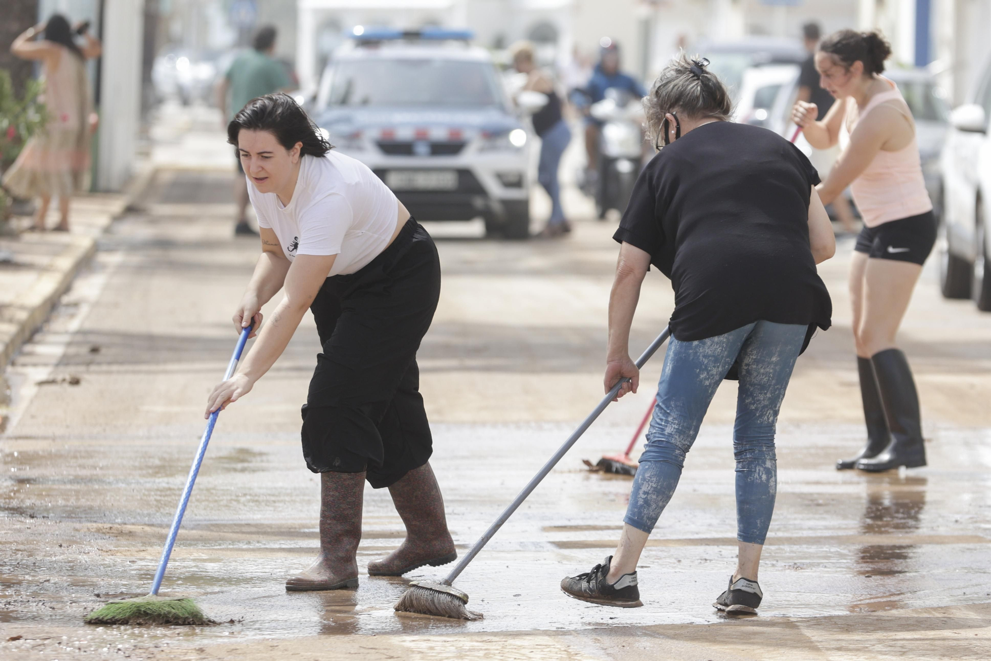 Varias mujeres barren las calles de Alcanar (Tarragona) tras las intensas lluvias de este domingo.