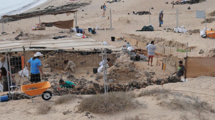 Imagen de una de las campañas de excavación en la playa de Las Conchas. En segundo plano, algunos turistas disfrutando del encanto del parque natural Islote de Lobos